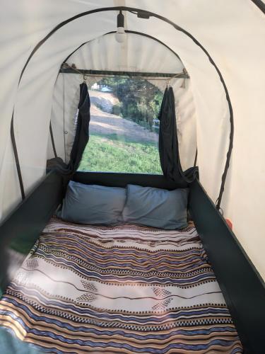 a bed in a tent with a window at La Calèche Western in Lafarre