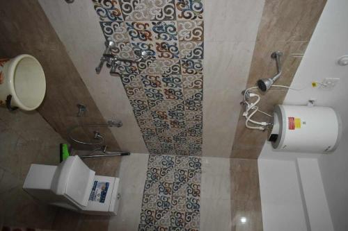 a bathroom with a shower curtain and a toilet at Devdaar Cottage Gangotri in Gangotri