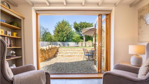 a living room with a sliding glass door to a patio at Garden Cottage in Chipping Campden