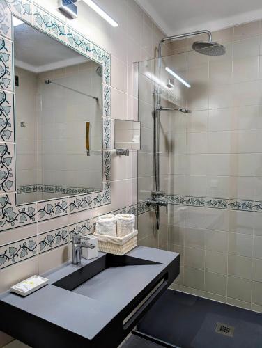 a bathroom with a sink and a mirror at 1A The Apartment in Albufeira