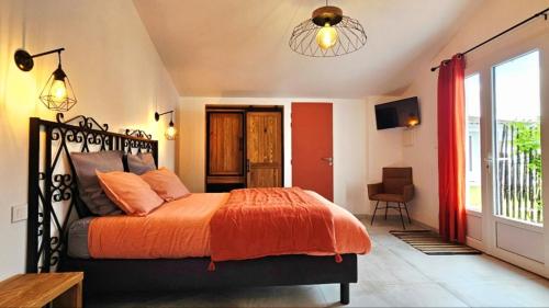 a bedroom with a bed with an orange blanket at Laubertière in Marennes
