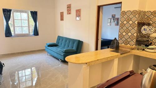 a living room with a blue couch and a blue chair at Riverside By GikiJoy in Agarvado