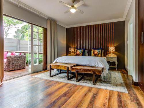 a bedroom with a bed and a ceiling fan at Wild Tree Lodge in Benoni