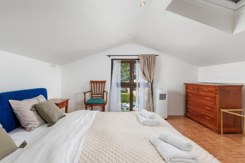 a bedroom with a large white bed and a dresser at Villa The Nest in Opatija