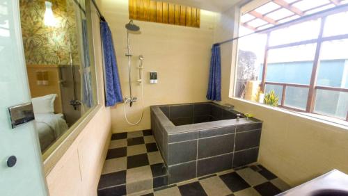 a large bathroom with a large tub and a window at 青禾溫泉家民宿 in Jiaoxi