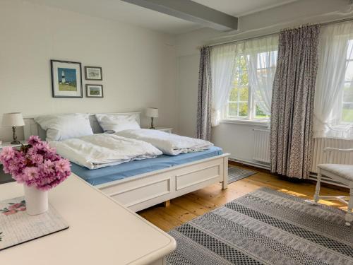 a bedroom with a bed and a table with flowers on it at Mühlenhof, Keitum auf Sylt in Sylt