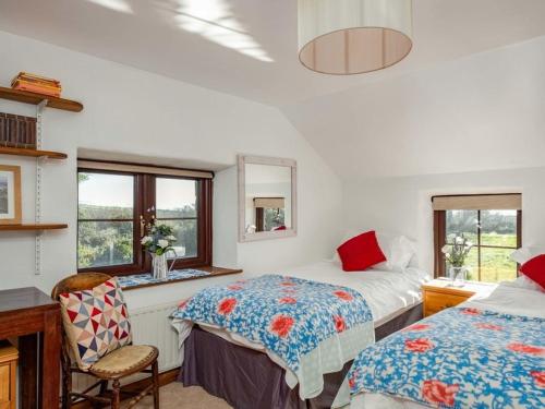 a bedroom with two beds and a desk and a chair at Trehaverock Cottage in Port Isaac