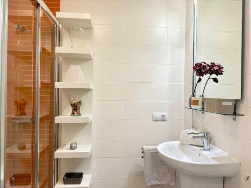 a white bathroom with a sink and a shower at Hortensia Suites Apartments, Los Cristianos, Tenerife in Los Cristianos
