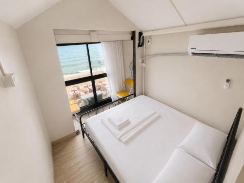 a small room with a bed and a view of the ocean at Noahs Ark Beach in Nathon Bay