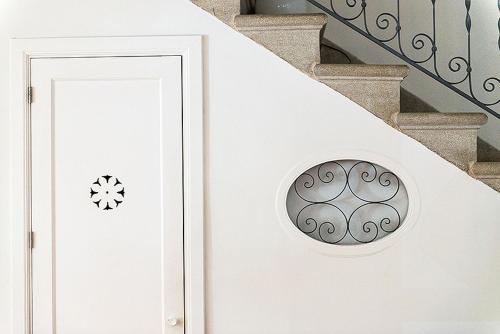 a white door with a round window on a staircase at Mon hotel in Ciutadella