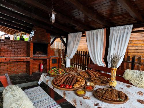 a table with many plates of food on it at Cabana Geta&Mircea in Beclean