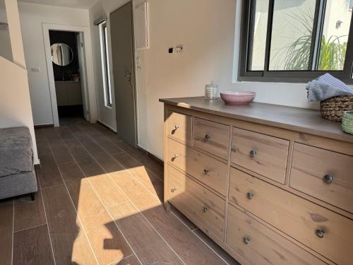 a bathroom with a wooden dresser with a sink on it at אצל מאיה ואבשי Maya and Avshi in Neʼot HaKikar