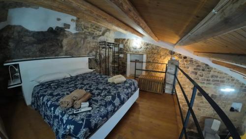 a bedroom with a bed in a stone wall at Casa ArTè in Modica