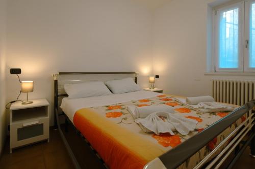 a bedroom with a large bed with an orange blanket at Villa Bianca in Perledo