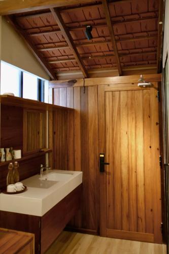 a bathroom with a sink and a wooden door at Soleil House in Hue