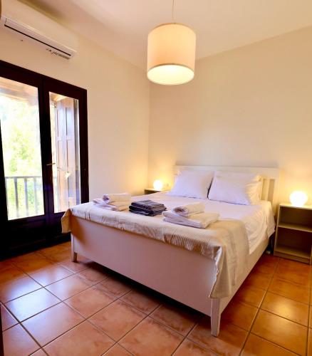 ein Schlafzimmer mit einem Bett mit weißen Laken und Kissen in der Unterkunft Mati Kat Studios in Kala Nera