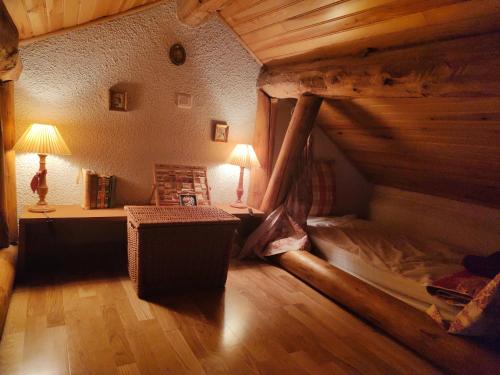an attic room with a bed and a table at L'Oursonnière de la Rende in Quérigut
