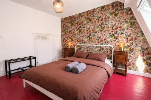 a bedroom with a large bed with a floral wallpaper at La Maison Créative in La Madeleine
