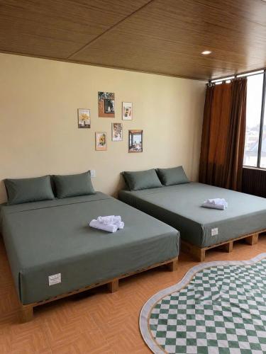 two beds sitting in a room with at Maison MAY Đà Lạt in Da Lat