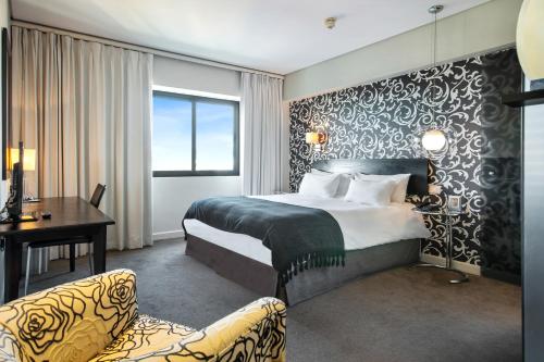 a hotel room with a bed and a desk at Colosseum Hotel in Cape Town