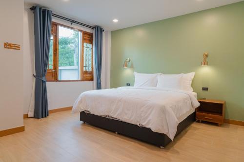 a bedroom with a large bed and a window at Baansiwalin in Phra Nakhon Si Ayutthaya