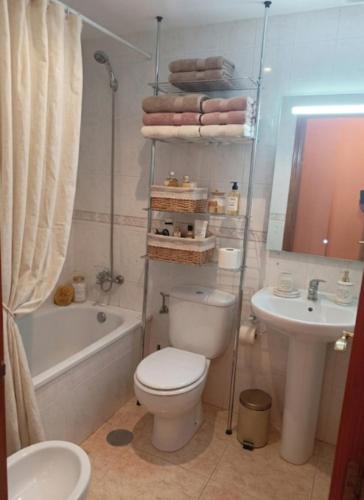 a bathroom with a toilet and a tub and a sink at Apartamento Belobodia in Cáceres