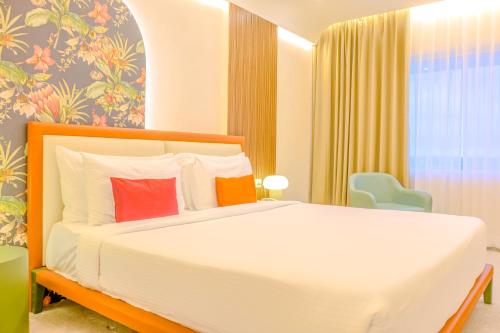 a bedroom with a white bed with red pillows at Terrea by Wonderla in Kumbalgod