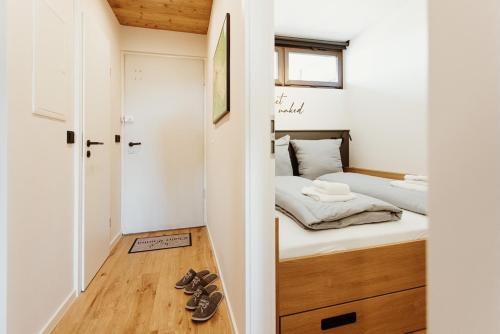 a small bedroom with a bed and shoes on the floor at Harzchalet Emma 4 Sankt Andreasberg in Sankt Andreasberg