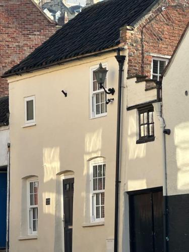 a white house with a black door and windows at The Nook Lincoln in Lincolnshire