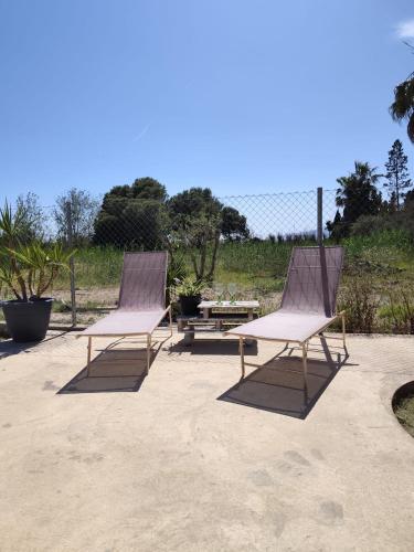 two chairs and a picnic table on a patio at La Caseta Dels Avis in Sant Jaume d'Enveja