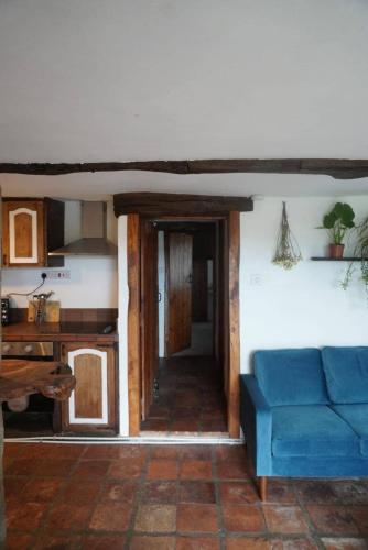 a living room with a blue couch and a table at Dairy Cottage in Hennock