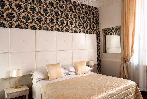 a bedroom with a bed and a wall with patterns at Albergo Rossini 1936 - Small & Charming in Bologna