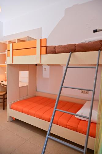 two bunk beds in a room with a desk at Clio Apartment in Gázion