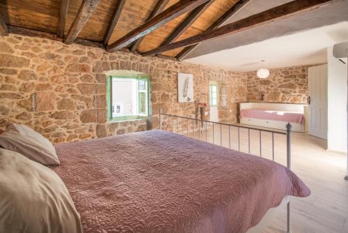 a bedroom with a bed and a stone wall at Villa Garica in Garica