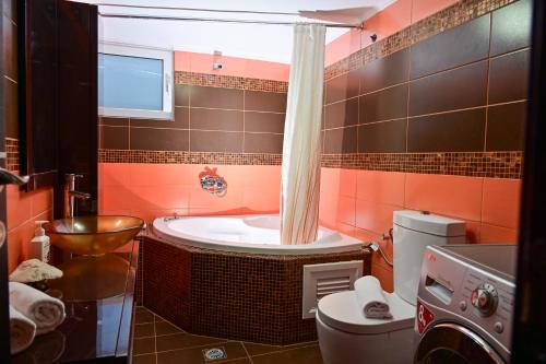 a bathroom with a tub and a toilet at Clio Apartment in Gázion