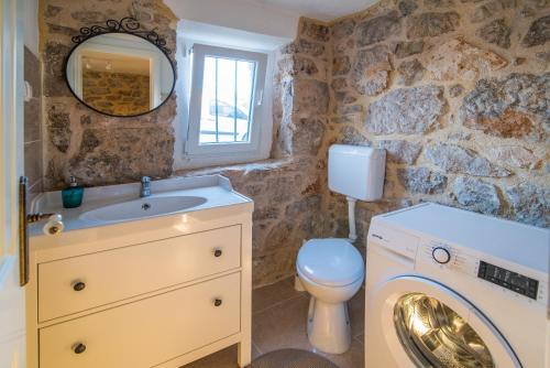 a bathroom with a sink and a washing machine at Villa Garica in Garica