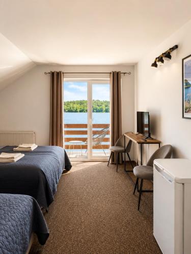 a hotel room with two beds and a desk and a window at Sielanka nad Junem in Mrągowo