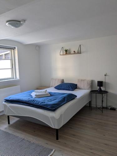 a bedroom with a large bed with blue sheets at 13min boxen, Legoland43min, MCH10min in Herning