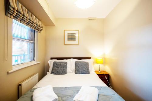 a small bedroom with a bed and a window at Harbourside View Whitby in Whitby