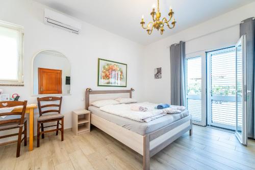 a bedroom with a bed and a table and chairs at Bed & Breakfast Haus Lucija in Baška