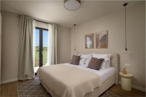 a bedroom with a large bed and a large window at Villa Modrić by IstriaLux in Trviž