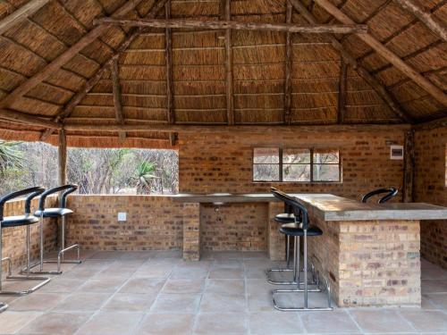 a patio with a bar in a brick building with stools at Nyala Lodge in Rayton
