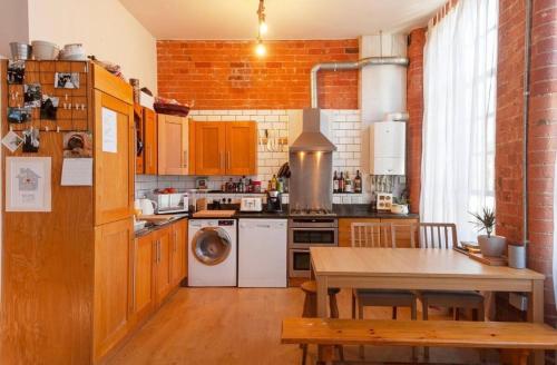 a kitchen with a table and a stove top oven at Raleigh Loft in Nottingham