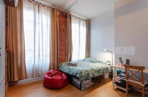 a bedroom with a bed and a window and a desk at Raleigh Loft in Nottingham