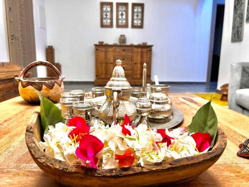 a bowl of flowers on a wooden table at Sweet Home in Ariana