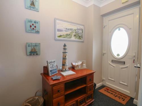 a room with a door and a dresser and a lighthouse at The Willows in Dymchurch
