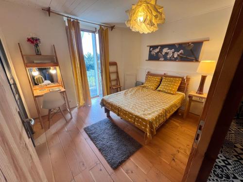 a bedroom with a bed and a table and a window at Charming apartment in Nyons in Nyons