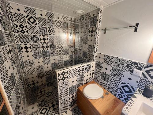 a bathroom with a toilet and a tiled wall at Charming apartment in Nyons in Nyons