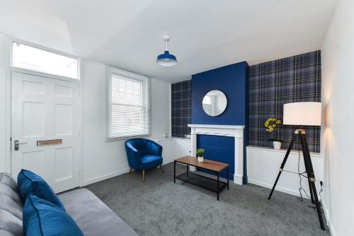 a living room with a couch and a blue accent wall at Newark Central Cottage in Newark-on-Trent