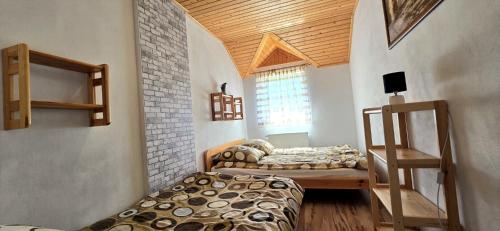 a bedroom with two beds in a room with a wooden ceiling at Wakacyjny Dom Dawidówka in Wisła